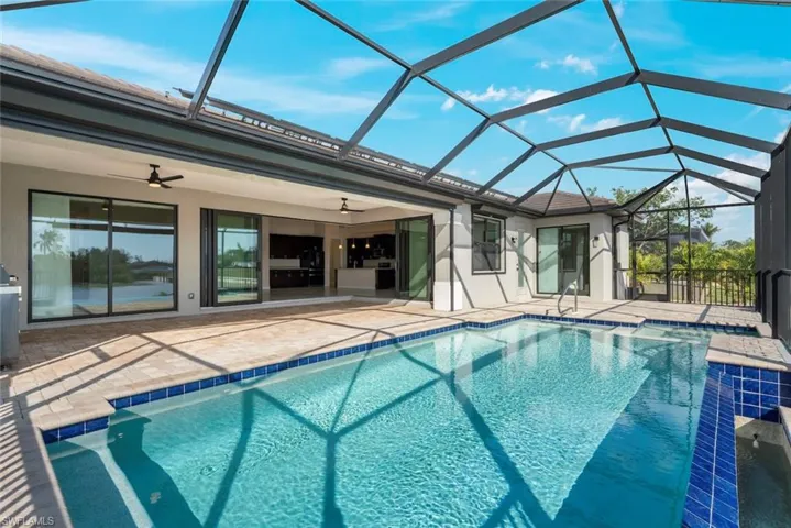 View of swimming pool featuring a patio, a lanai, and ceiling fan