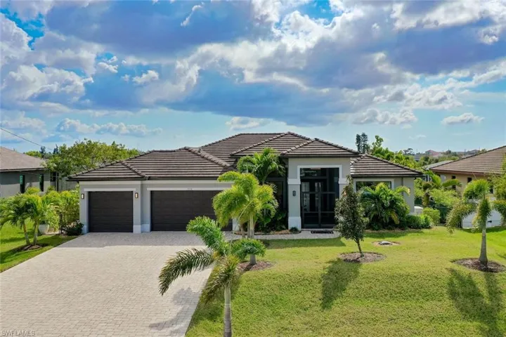 View of front of property featuring a garage and a front yard