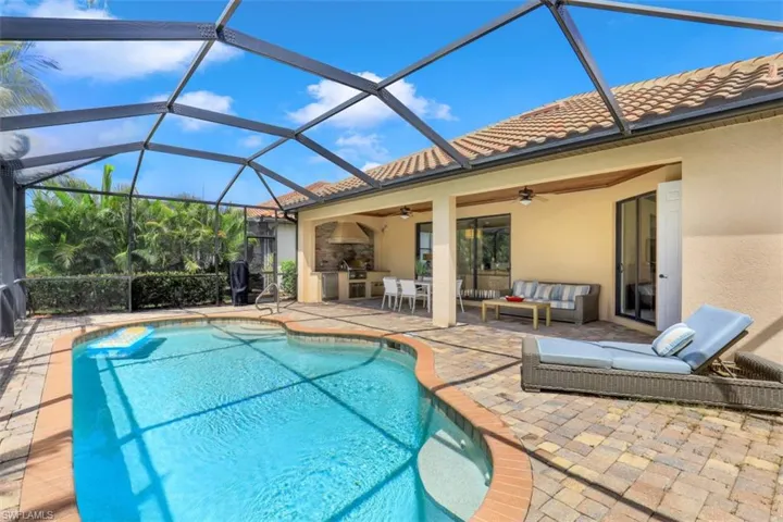 Outdoor pool featuring a patio, ceiling fan, an outdoor hangout area, a lanai, and exterior kitchen