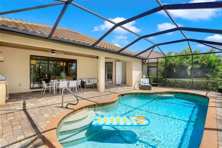 Outdoor pool featuring a patio area, a ceiling fan, outdoor lounge area, and glass enclosure