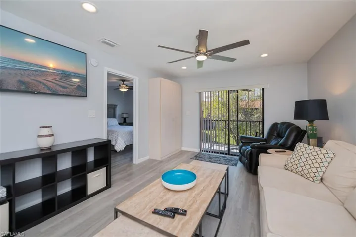 Living room with light wood-type flooring, recessed lighting, and ceiling fan