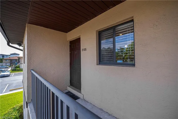 Doorway to property featuring a porch and stucco siding