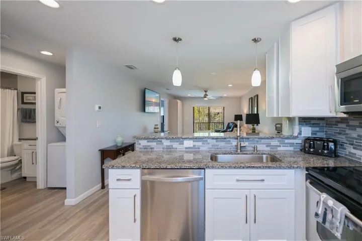 Kitchen featuring white cabinets, a peninsula, tasteful backsplash, and recessed lighting