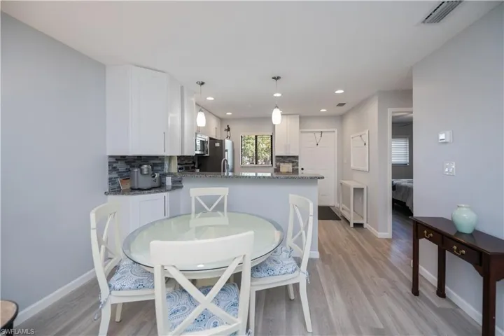 Dining room with recessed lighting and light wood-type flooring