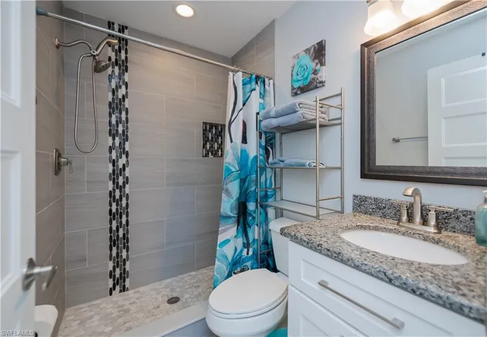 Full bath with vanity, a stall shower, and recessed lighting