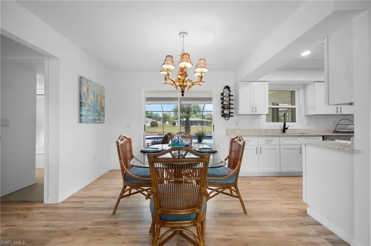 Light wood-finish flooring throughout, featuring a bright open concept with a kitchen pass-through