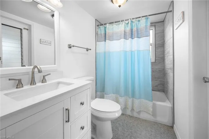 White vanity with an integrated rectangular sink, brushed nickel faucet, and coordinating hardware