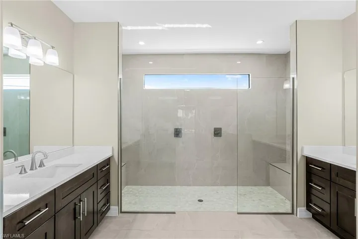 Full bath featuring two vanities, walk in shower, light tile patterned floors, and recessed lighting
