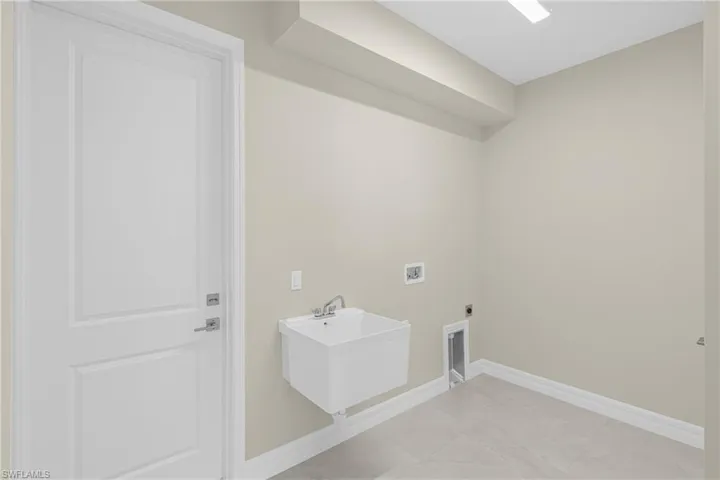Laundry area featuring hookup for a washing machine, hookup for an electric dryer, and light tile patterned flooring