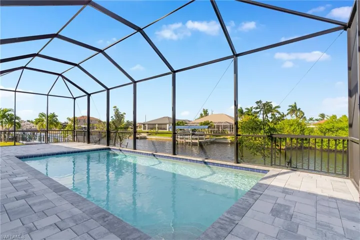 Outdoor pool with a sunroom, a water view, a lanai, and a residential view