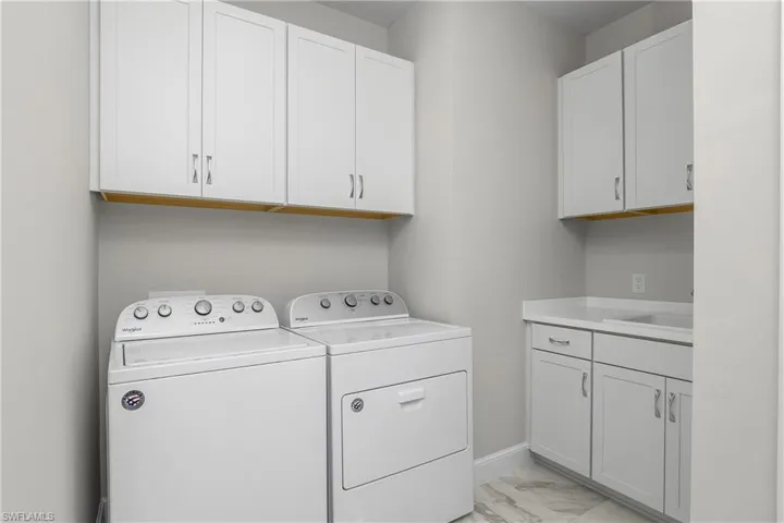 Laundry room features utility sink, washer/dryer, and LOTS of additional storage!