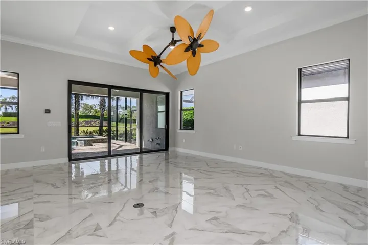 Freshly painted interior with great room featuring coffered ceiling, crown molding, a wealth of natural light, and beamed ceiling.