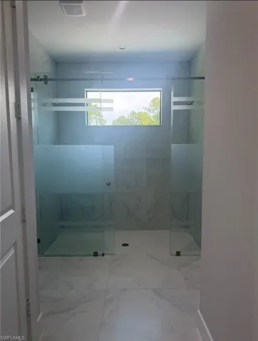 Full bathroom featuring a marble finish shower and marble finish flooring