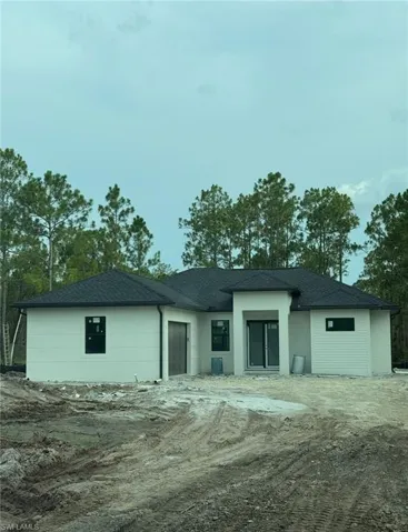 Back of property featuring a shingled roof