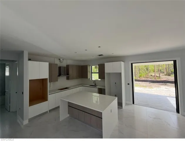 Kitchen with modern cabinets, a kitchen island, and white cabinetry