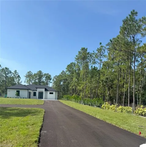 View of front of home featuring a front yard and asphalt driveway