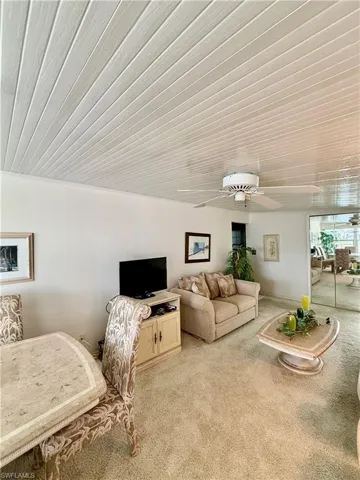 Living area featuring a ceiling fan and light colored carpet