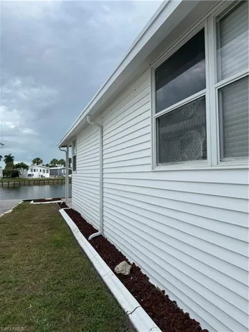 View of property exterior featuring a lawn and a water view