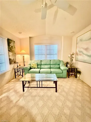 Living room with carpet flooring and a ceiling fan