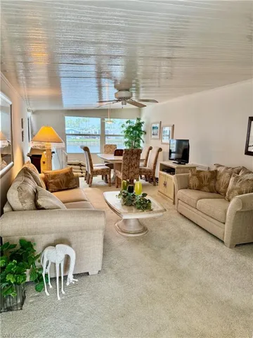 Living room featuring ceiling fan and light colored carpet