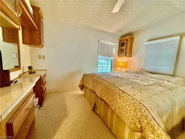 Bedroom with light carpet and ceiling fan