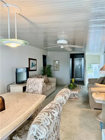 Carpeted living area with ceiling fan