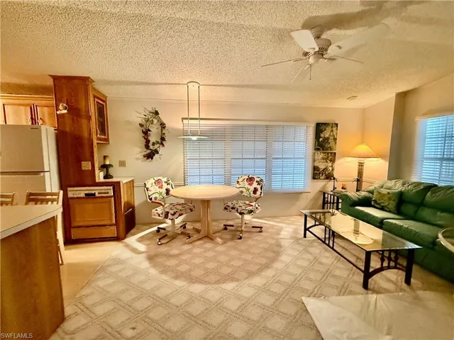 Living area featuring ceiling fan and a textured ceiling