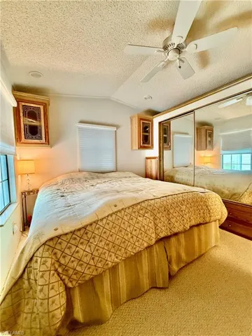 Bedroom featuring carpet flooring, a ceiling fan, and a closet