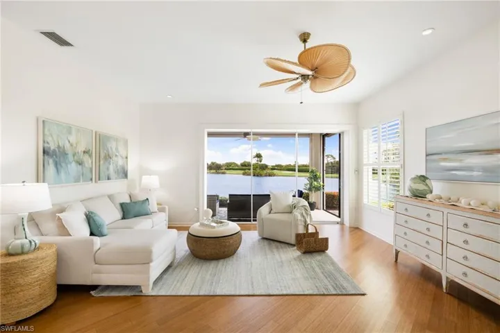 Living room with wood finished floors, a water view, recessed lighting, and ceiling fan