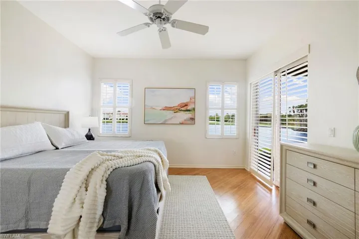 Bedroom featuring access to exterior, light wood-style flooring, and ceiling fan