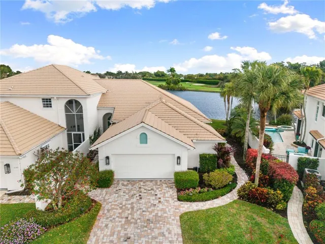 Mediterranean / spanish-style home with a water view, stucco siding, decorative driveway, and an attached garage
