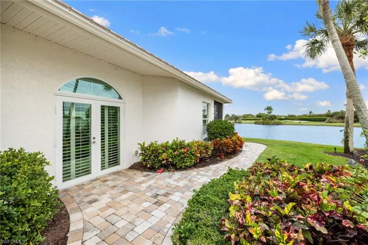 View of grassy yard featuring a water view and french doors
