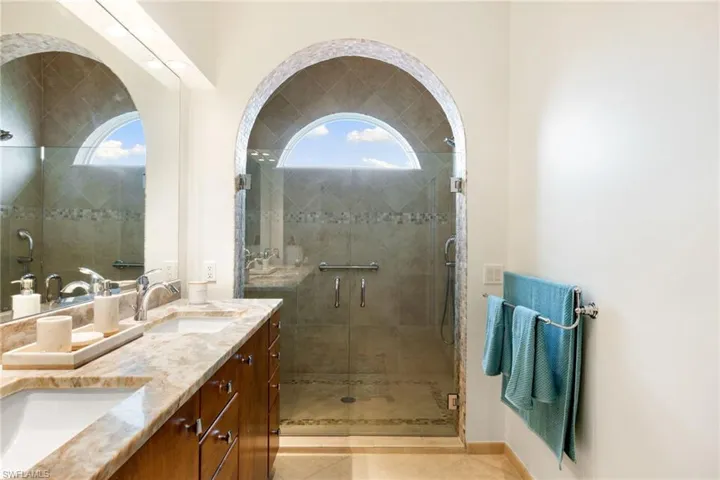 Full bath featuring double vanity and a shower stall