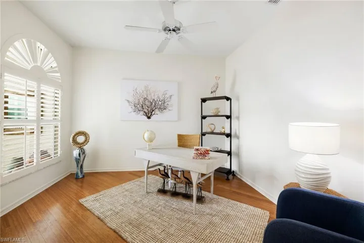 Home office with wood finished floors and a ceiling fan