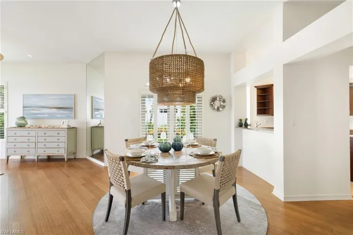 Dining area with light wood finished floors, a chandelier, and built in shelves