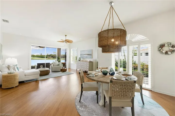 Dining space featuring light wood-type flooring, a chandelier, and a water view