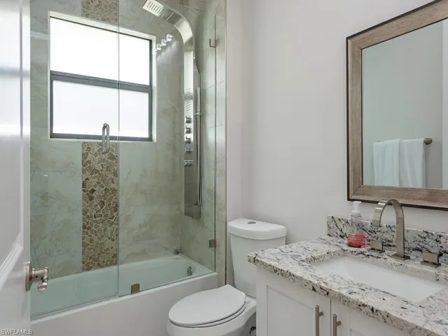 Full bathroom with shower / bath combination with glass door and vanity