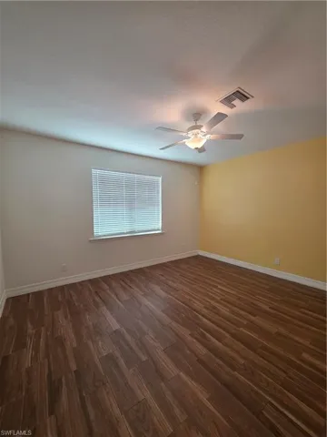 Wood-finish flooring, overhead ceiling fan with integrated lighting, and a window with horizontal blinds