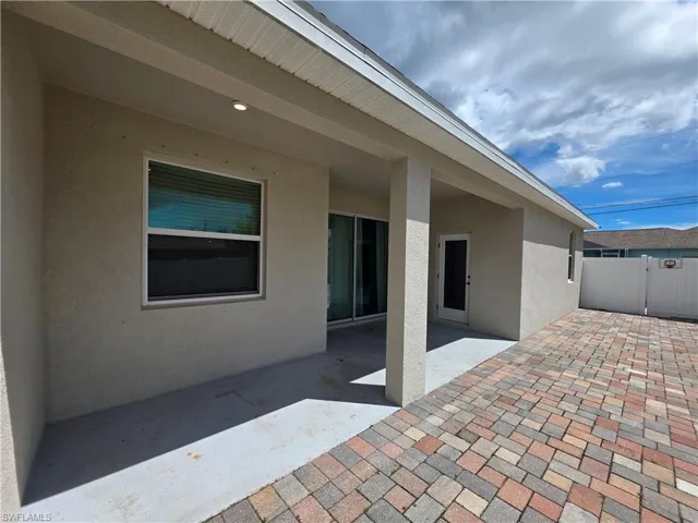 Covered patio featuring recessed lighting, sliding glass doors, and a paver walkway