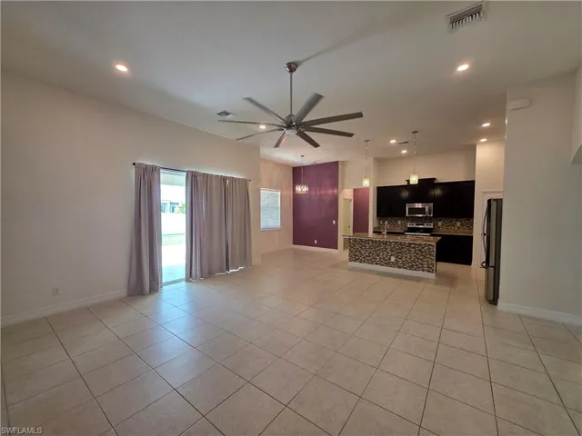 Spacious interior with tile flooring, recessed lighting, and a modern ceiling fan