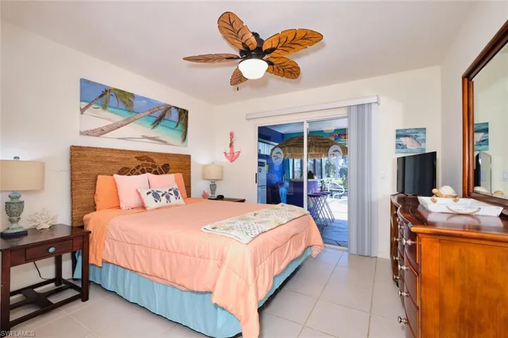 Bedroom featuring access to exterior, light tile patterned floors, and a ceiling fan