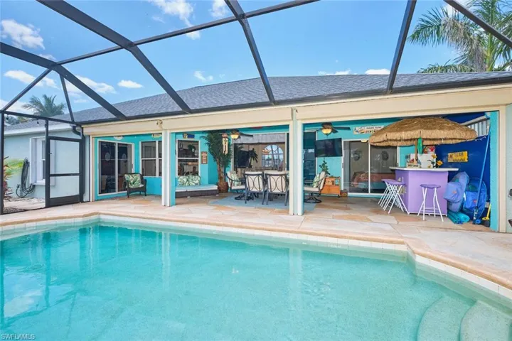 Pool with a lanai, a patio, outdoor dry bar, and a ceiling fan