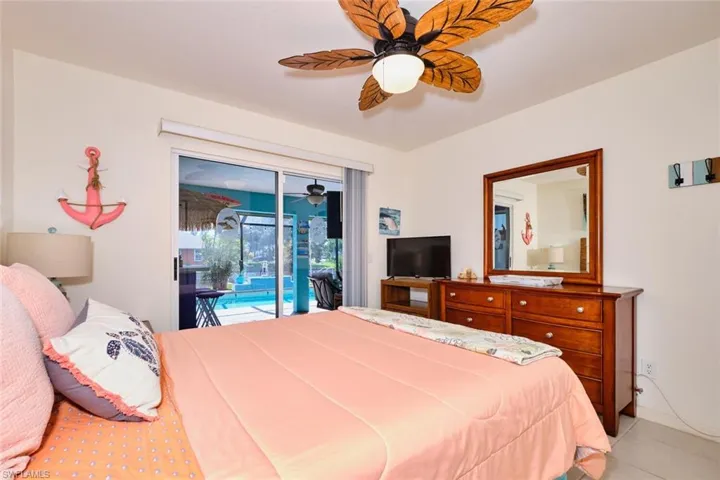 Bedroom featuring light tile patterned flooring, access to exterior, and ceiling fan