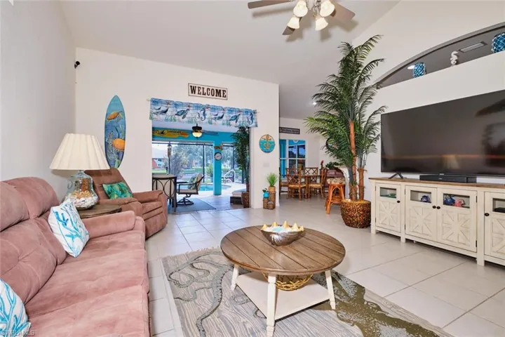 Living area featuring light tile patterned floors and a ceiling fan