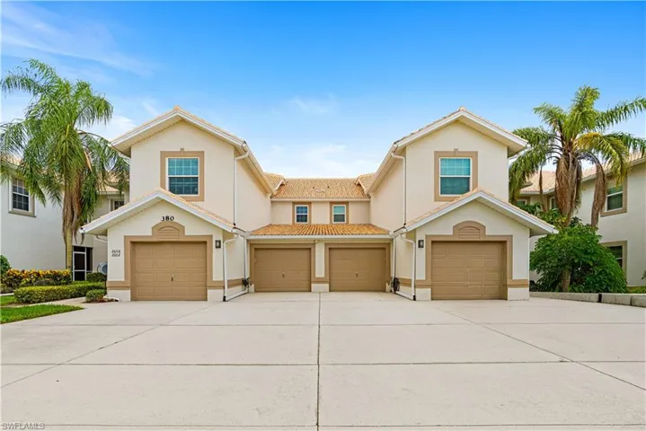 Multi-unit structure featuring stucco exterior, arched window accents, and tile roofing