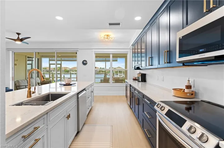 Gourmet kitchen featuring a large central island with an undermount sink and a gooseneck faucet
