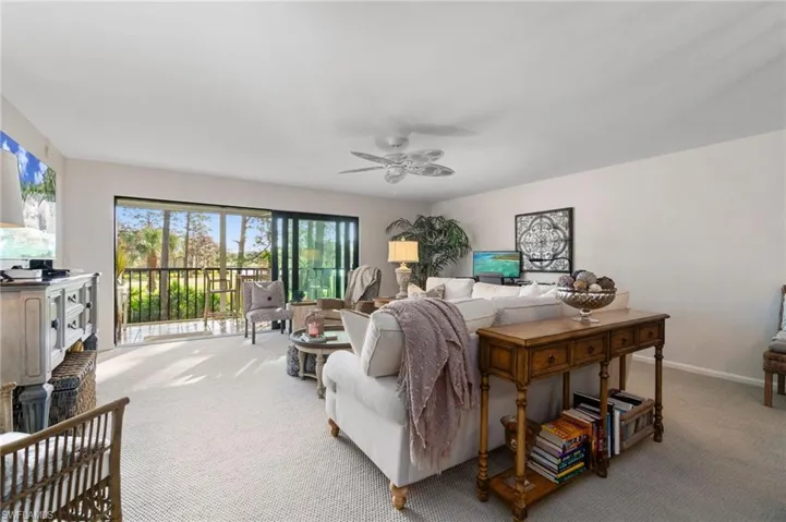Living room with light carpet and ceiling fan