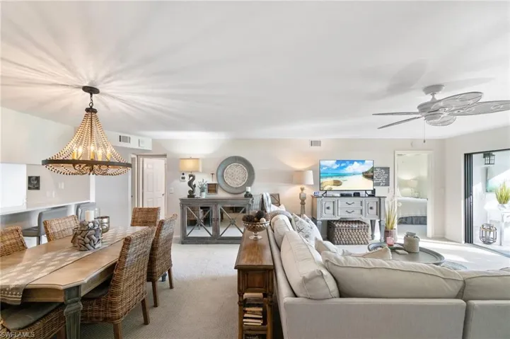 Carpeted living room featuring ceiling fan