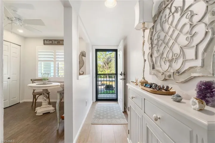 Doorway with hardwood / wood-style flooring, ceiling fan, and a healthy amount of sunlight