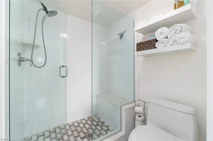 Bathroom featuring toilet and an enclosed shower
